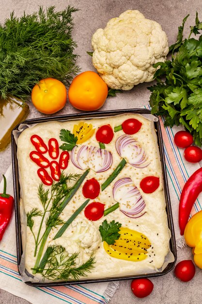 Rauwe tuin focaccia. Vers deeg en groenten, olijfolie, Groenen