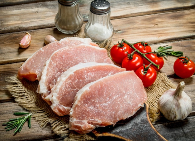 Rauwe varkenslapjes vlees met tomaten en rozemarijn