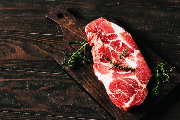 Rauwe varkenssteak op een houten plank