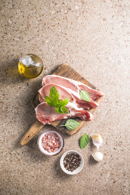 Rauwe varkenssteaks met specerijen kruiden op snijplank Vers vlees Bovenaanzicht kopieerruimte