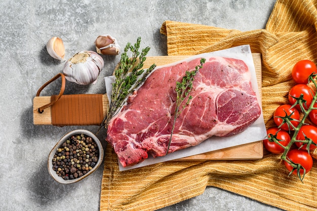 Rauwe varkensvlees steak in de buurt van kruiden