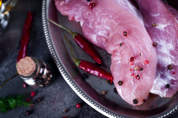 Foto rauwe vers vlees steak entrecote en kruiderijen in de ijzeren plaat met olie, chili, kruiden dille