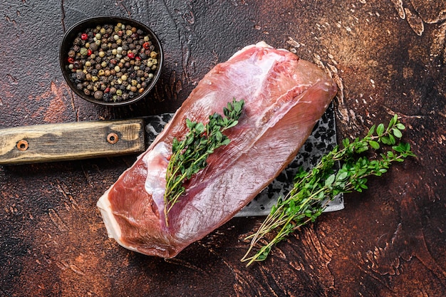 Rauwe verse eendenborstfilet steak op een hakmes. Donkere achtergrond. Bovenaanzicht.