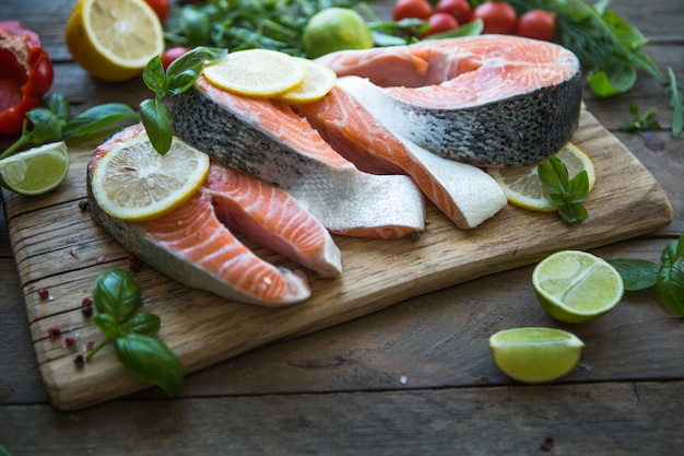 Rauwe, verse zalm steak op een steen en basilicum, schijfje citroen rond. Rauwe zalm rode vis.