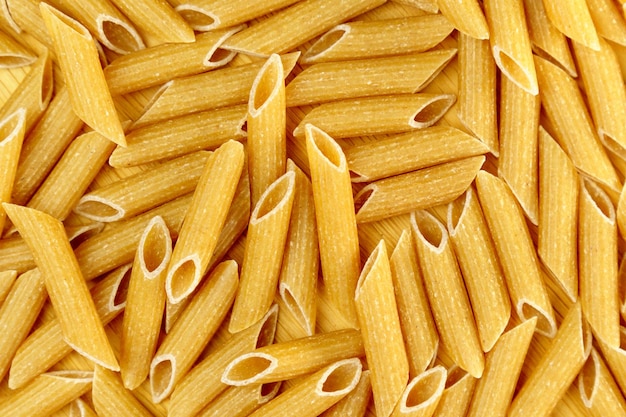 Foto rauwe volle granen pasta penne rigate koken pasta selectieve aandacht koken zelfgemaakt eten textuur