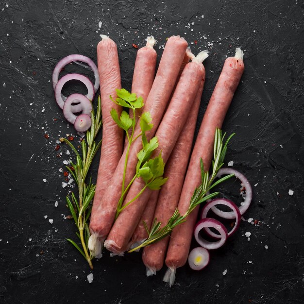 Rauwe worstjes met rozemarijn en groenten Bovenaanzicht Vrije ruimte voor uw tekst