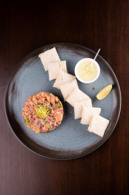 rauwe zalm tartare met toast saus en citroen top view