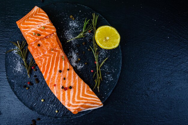 Rauwe zalmfilet en kruiden op een leisteen bord. Bovenaanzicht