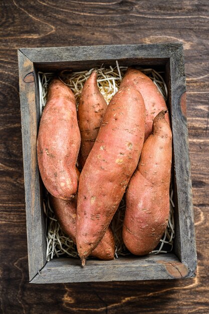 Rauwe zoete aardappel op houten tafel.