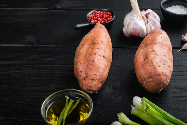 Rauwe zoete aardappelen met kruiden op een houten tafel