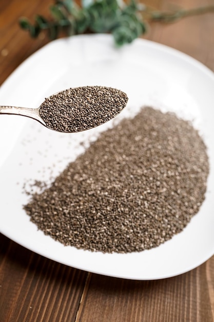 Rauwe zwarte quinoa zaden op bord en lepel