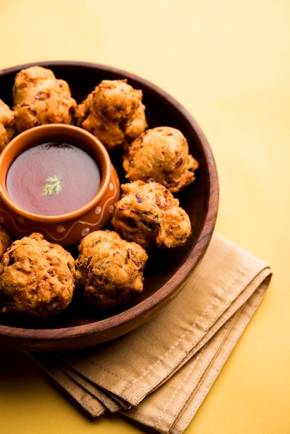 Rava Bhajjまたはbhajiyaは、sujiPakodaまたはsemolinaPakoraとも呼ばれ、トマトケチャップを添えています。セレクティブフォーカス