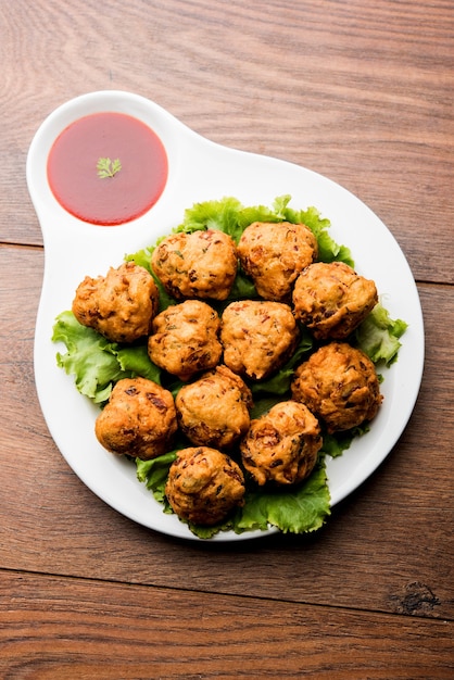 Rava Bhajj or bhajiya also known as suji Pakoda or semolina Pakora, served with tomato ketchup. selective focus