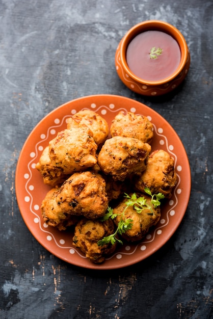 Rava Bhajj of bhajiya ook bekend als suji Pakoda of griesmeel Pakora, geserveerd met tomatenketchup. selectieve focus