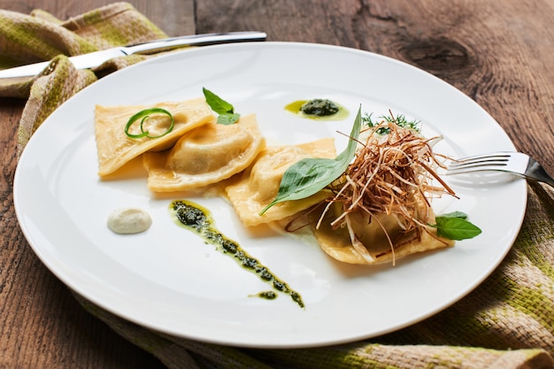 Foto ravioli met eend en roomsaus, geserveerd op een witte plaat