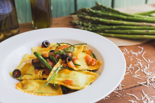 Foto ravioli con olive, asparagi e pomodoro