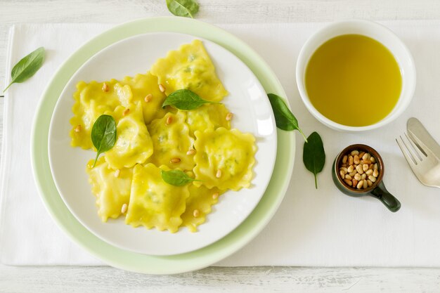 Ravioli with ricotta and spinach, served with olive oil and pine nuts