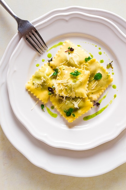 Ravioli with spinach and cheese green sauce on a light background selective focus no people