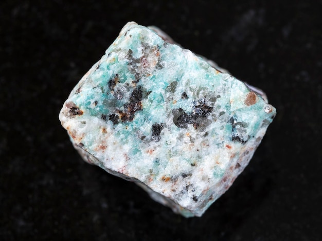 Raw amazonite granite stone on dark background