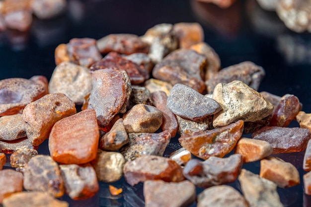 Raw amber from the shores of the Baltic Sea Pieces of raw amber lie on black glass Raw material for the production of jewelry