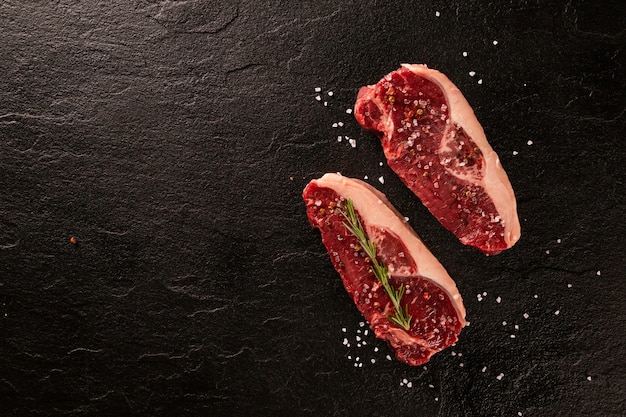 Carne di ancho cruda da cucinare su tagliere scuro. fondo in legno.