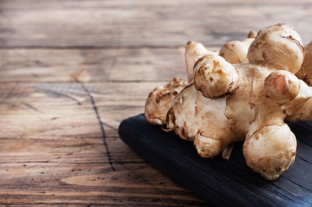 Raw artichoke roots on wooden board