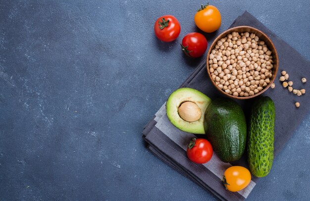 Raw Avocado,Cucumber, Tomato and chickpea on Concrete Stone Table Background.