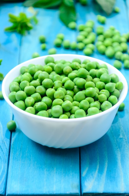 RAW baby peas in small white bowl