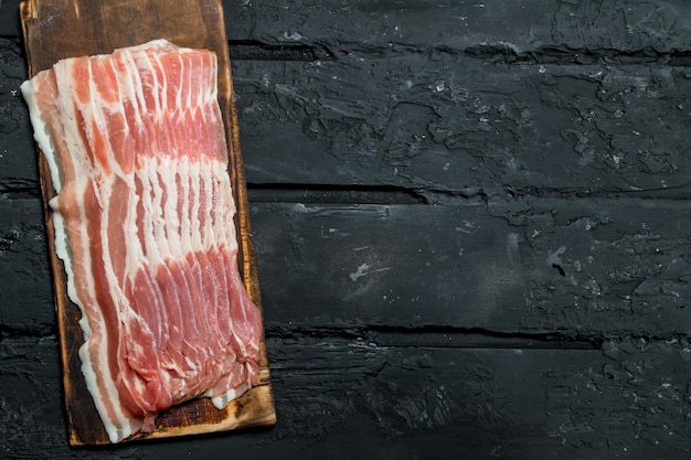 Raw bacon on a cutting Board