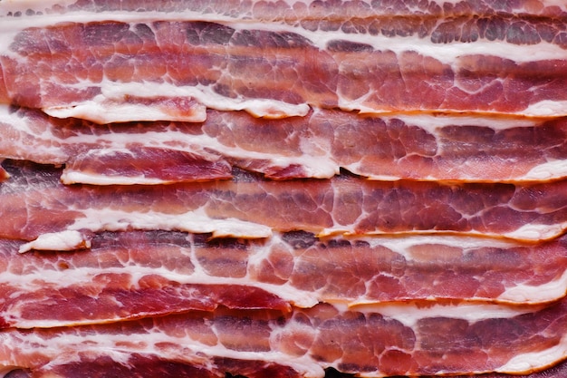 Raw bacon slices background top view