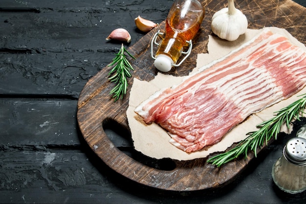 Photo raw bacon with rosemary and spices