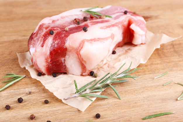 Raw bacon with spices on wooden table