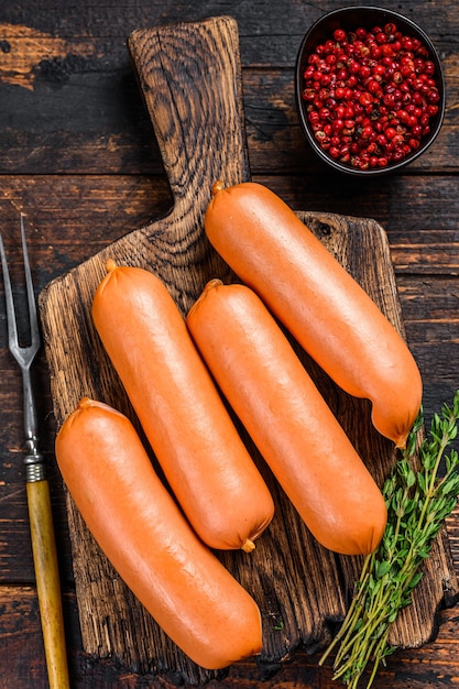 Raw barbecue sausages bratwurst from pork meat on a cutting board. 