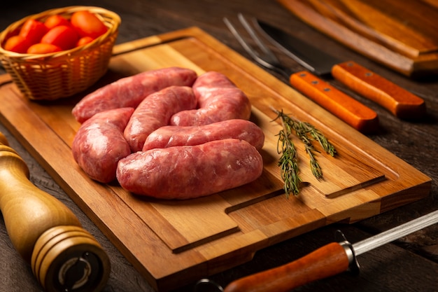 Raw barbecue sausages ready to roast on the wooden table