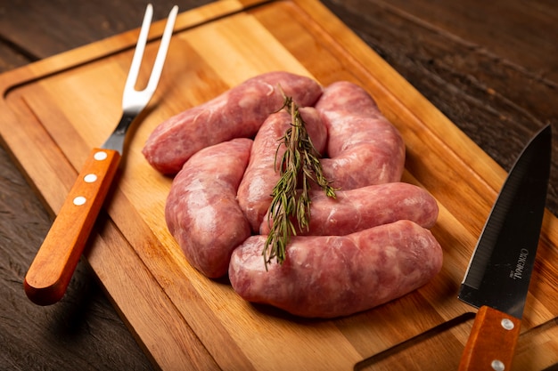 Raw barbecue sausages ready to roast on the wooden table