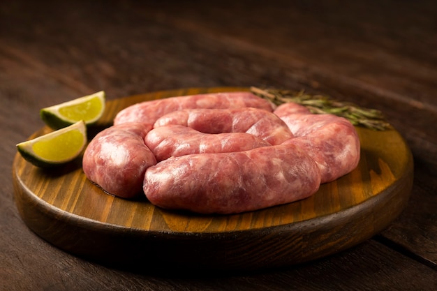 Raw barbecue sausages ready to roast on the wooden table