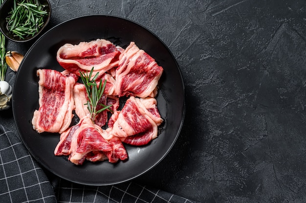 Raw beef bacon, marbled meat in a plate