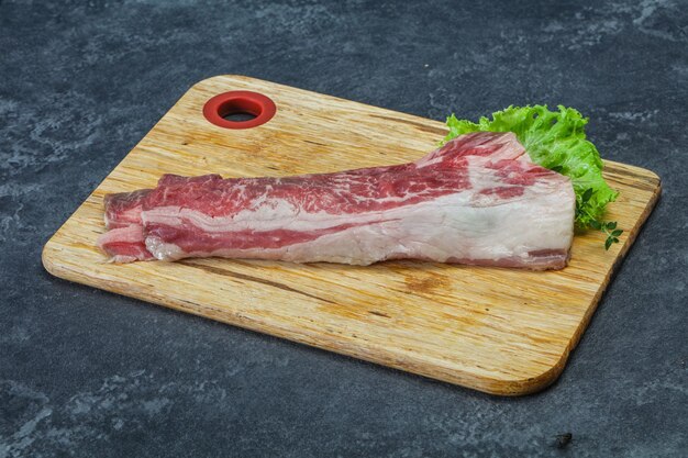 Raw beef bacon over wooden board