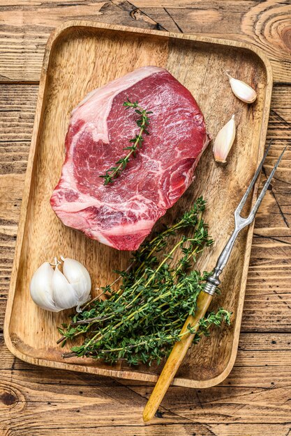 Raw beef Club steak on a cutting board. wooden background. Top view.