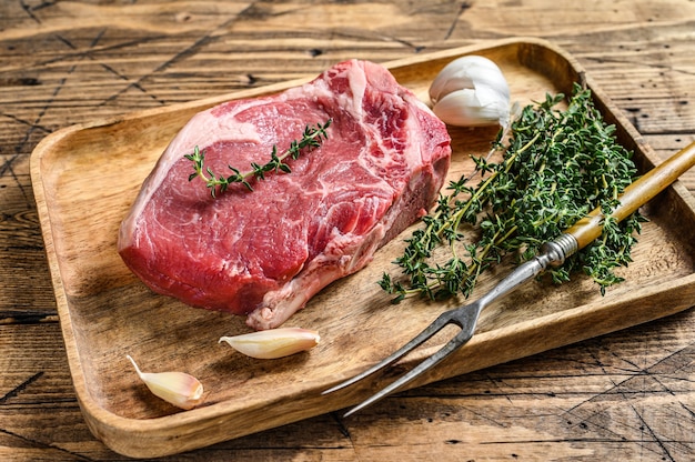 Raw beef Club steak on a cutting board. wooden background. Top view.