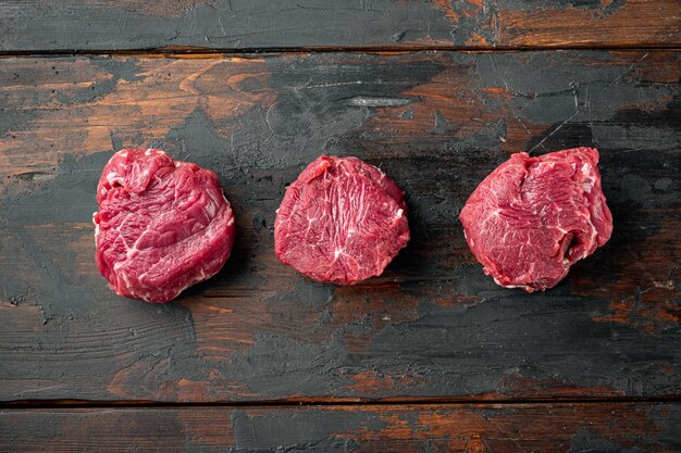 Raw beef fillet steaks with spices set, on old dark wooden table