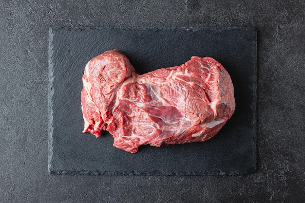 Raw beef meat on a black serving plate