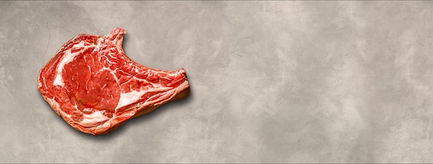 Raw beef prime rib isolated on light concrete background. Top view. Horizontal banner