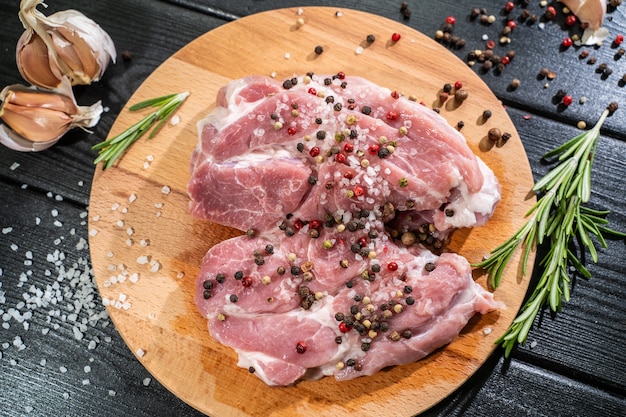 Raw beef steak on a dark wooden table.