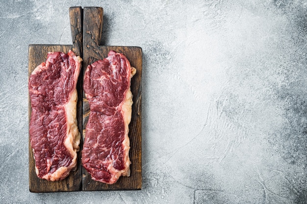 Raw beef steak, on gray background, top view flat lay  with copy space for text