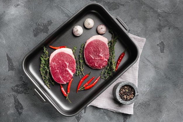 Raw beef steak set on gray stone table background top view flat lay with copy space for text