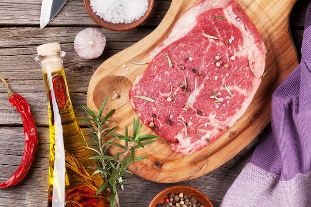 Raw beef steak with spices and herbs