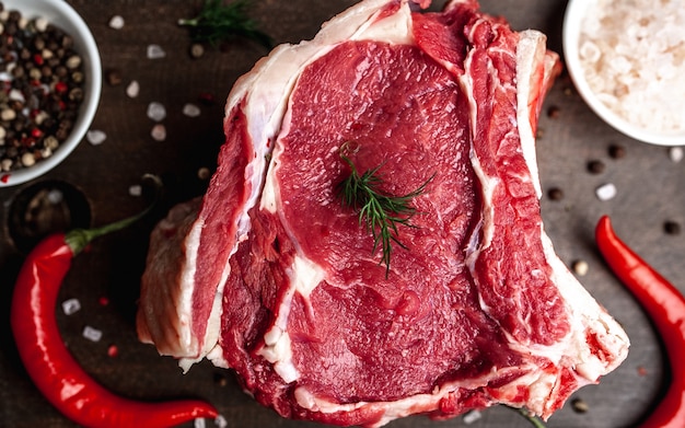 raw beef steak with spices on wood