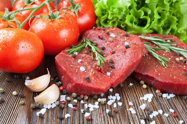 Raw beef steak with vegetables and spices