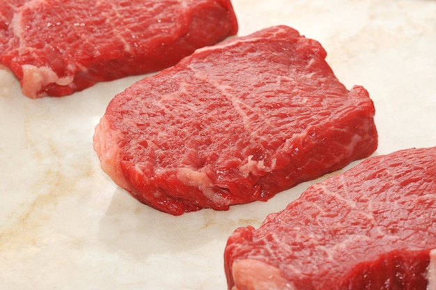 Raw beef steaks on marble background